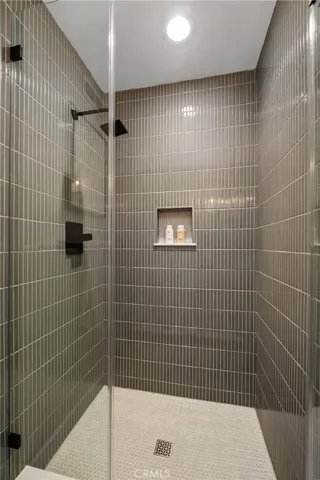 SHOWER IN DOWNSTAIRS BATHROOM WITH DESIGNER DETAILS IN THE TILE WORK AND RAIN SHOWER FIXTURES.