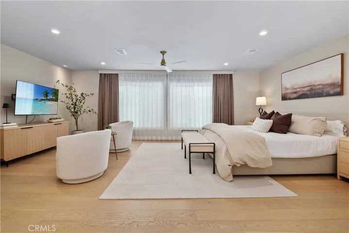 BEAUTIFUL AND TRANQUIL PRIMARY BEDROOM WITH PICTURE WINDOW, CUSTOM WINDOW COVERINGS, GORGEOUS WOOD FLOORING, REESSED LIGHTING, AND A SMALL PATIO TO RELAX AND ENJOY .TV PICTURE ADD