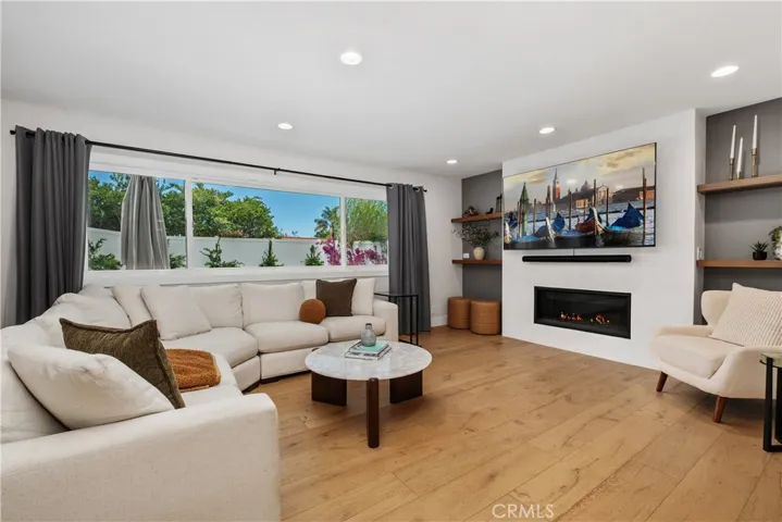 BEAUTIFUL RICH WOOD FLOORING THROUGHOUT HOME, DESIGNER MODERN FIREPLACE WITH FIRE ON ICE.
LARGE PICTURE WINDOW EXTENING ACROSS ENTIRE WALL FOR NATURAL LIGHT AND VIEWS OF SPACIOUS LUSH BACKYARD.
