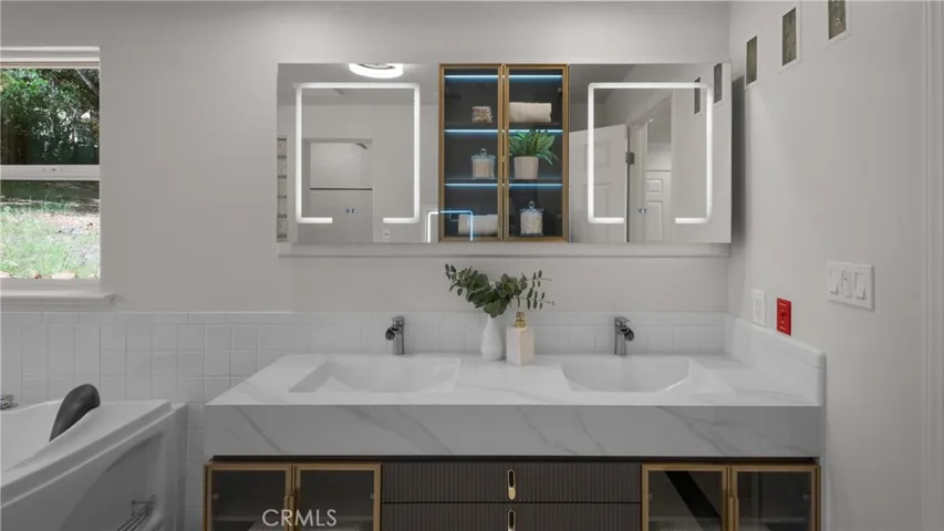 Primary bathroom features  floating vanity with dual sinks and lighted mirrors