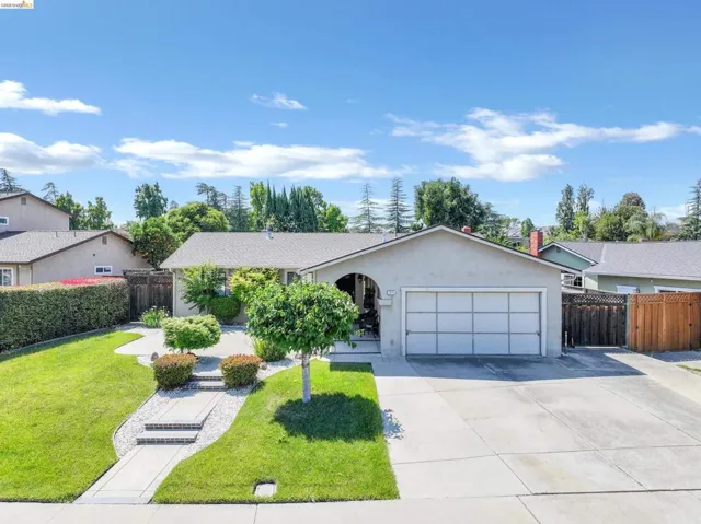 Single-story residence featuring a two-car garage, concrete driveway, and front lawn