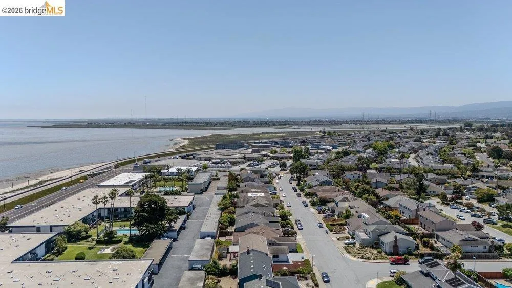 Aerial perspective showcasing a residential area with proximity to a large body of water