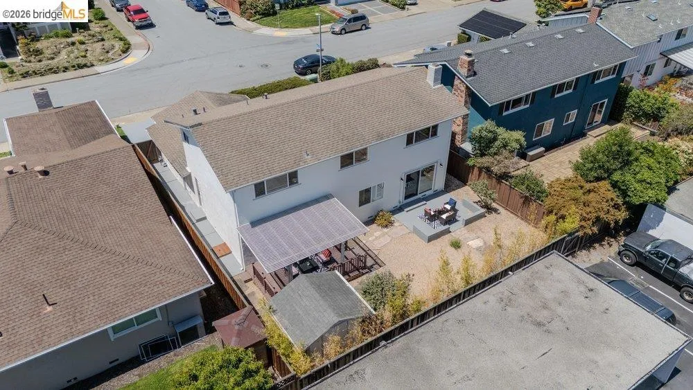 Rear exterior featuring a spacious gravel yard with a dedicated patio area