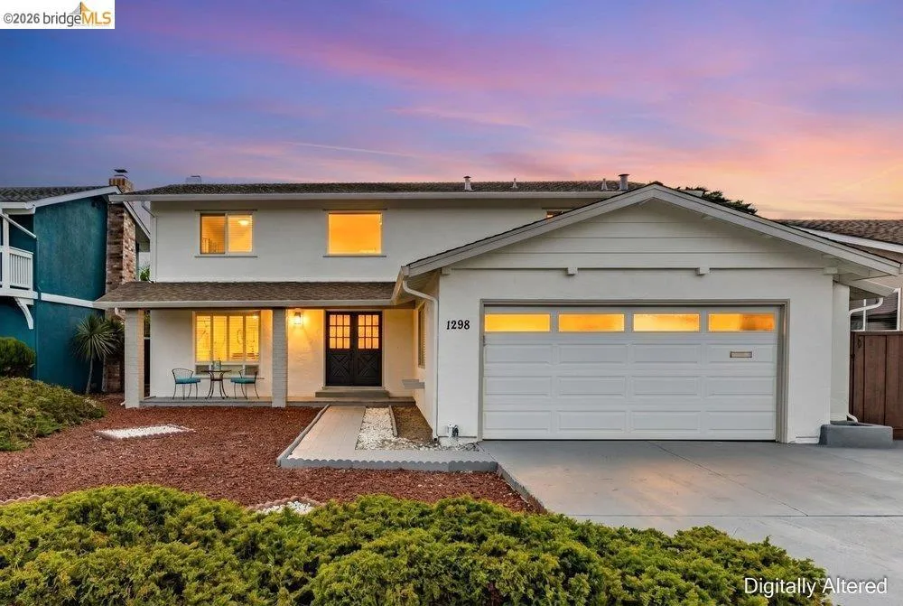 Two-story residence featuring a white stucco exterior and an attached garage with translucent paneling