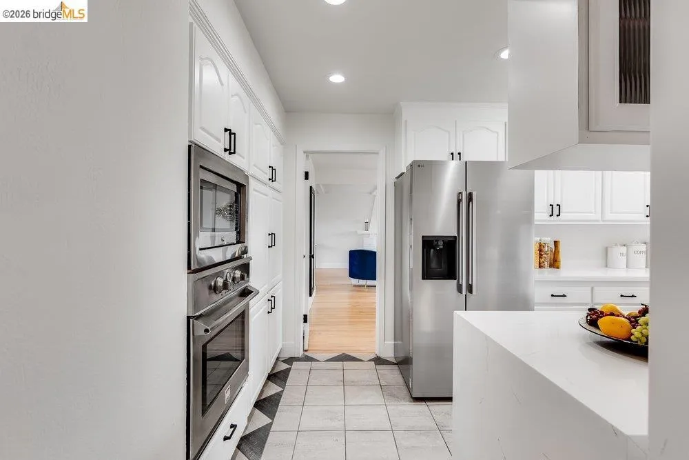 Kitchen featuring white cabinetry, stainless steel appliances, recessed lighting, and a patterned tile floor