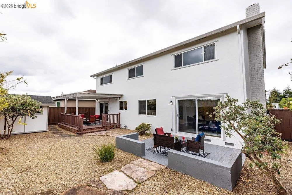 Spacious backyard featuring two distinct patio areas, one with a pergola overhead