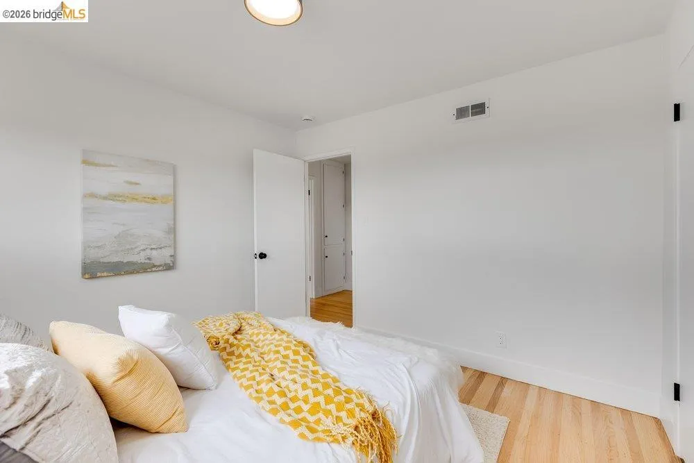 Bright room with light wood-finish flooring, white walls, and white trim