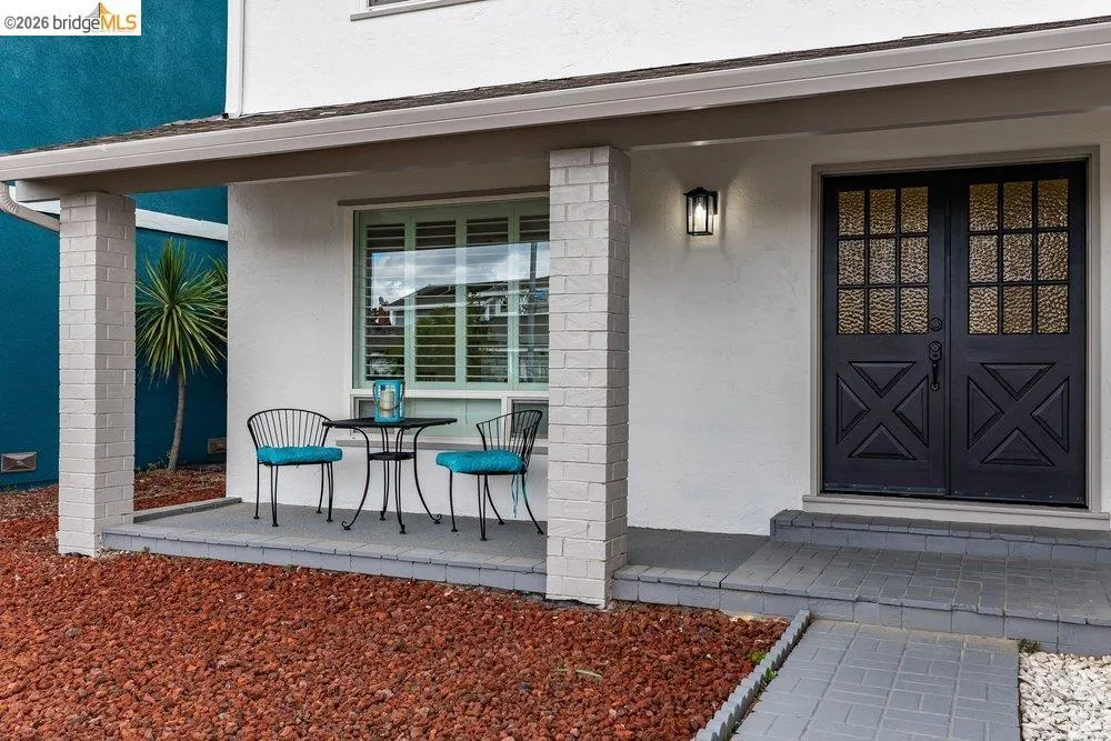 Covered front porch featuring brick columns and a paver walkway