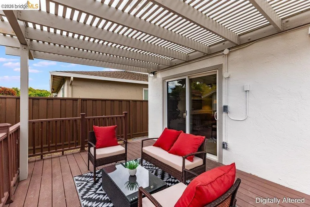 Outdoor patio featuring a slatted pergola, composite decking, and wood fencing