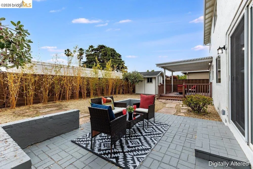 Paved patio area with a privacy fence featuring tall bamboo plantings