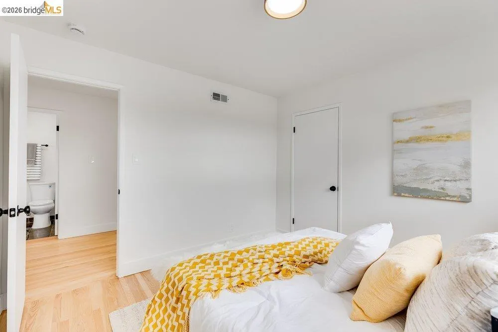 Room featuring light wood-finish flooring, white walls, and a contemporary flush-mount ceiling light