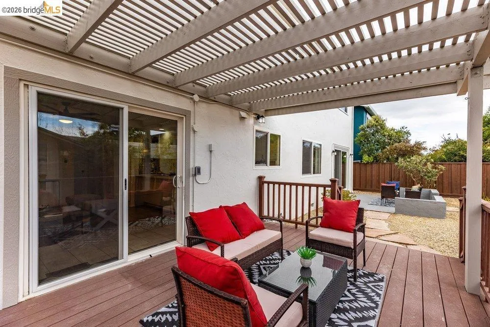 Expansive outdoor deck featuring a slat patio cover, wood-finish decking, and direct access to the interior via sliding glass doors