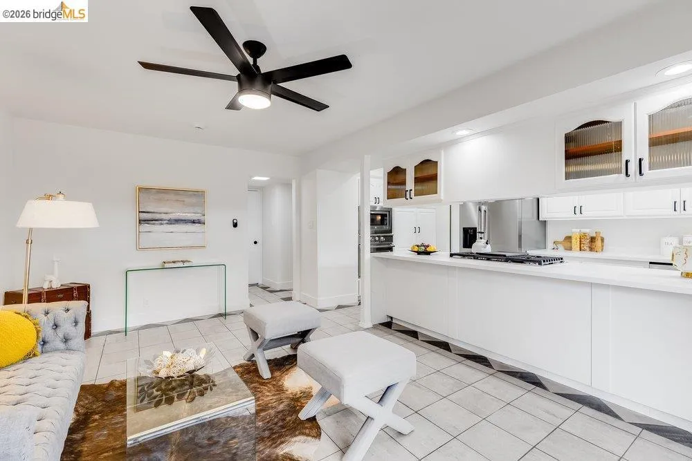 Open-concept living space with white walls and a black ceiling fan