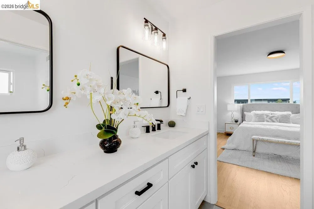 Double vanity with a white countertop and dual undermount sinks, complemented by black framed mirrors and matte black fixtures