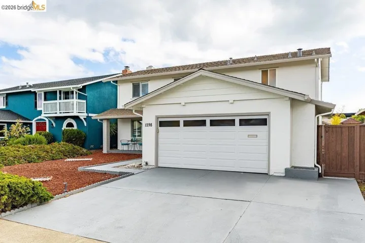White stucco exterior with a two-car garage and a paved driveway