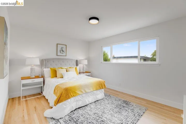 Bright room featuring light wood flooring, white walls, and a large horizontal window