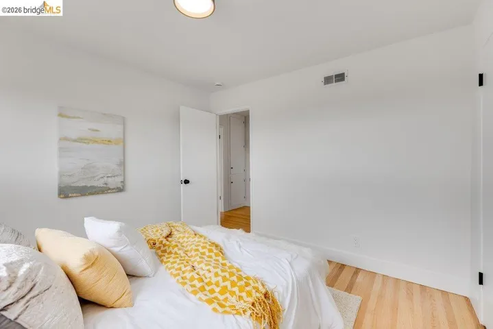 Bright room with light wood-finish flooring, white walls, and white trim