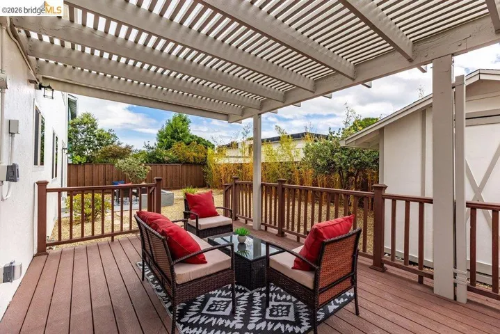 Expansive outdoor deck featuring composite flooring and a slatted pergola overhead