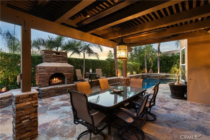Covered outdoor entertaining area, a stone fireplace, and multiple seating spaces