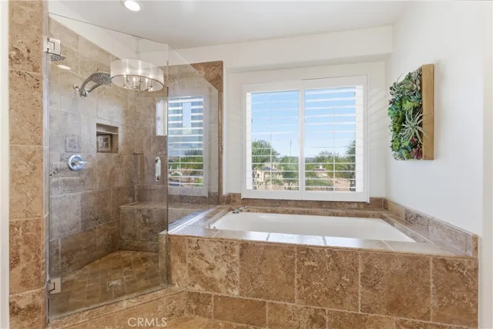 Spa-inspired primary bathroom with dual vanities, a soaking tub, and oversized walk-in shower