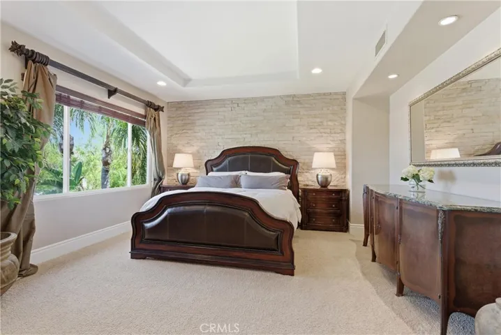 Spacious primary suite with a private sitting area, abundant natural light, and picturesque hillside and neighborhood views