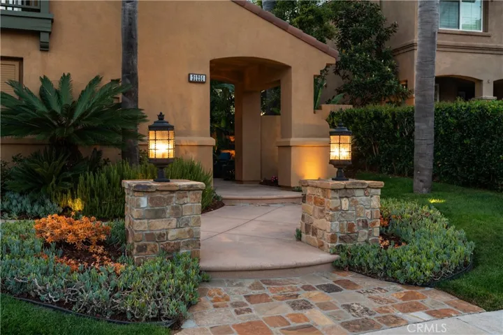 Beautifully landscaped entry with stone accents and ambient lighting