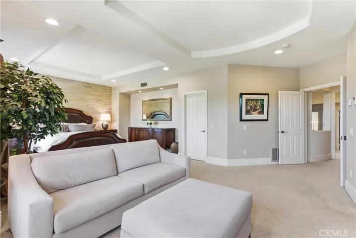 Spacious primary suite with a private sitting area, abundant natural light, and picturesque hillside and neighborhood views