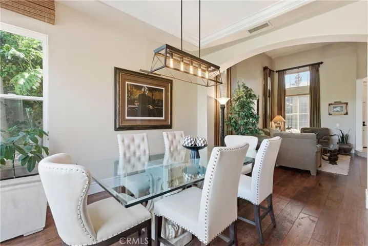 Formal dining area with designer lighting and French doors opening to the private backyard
