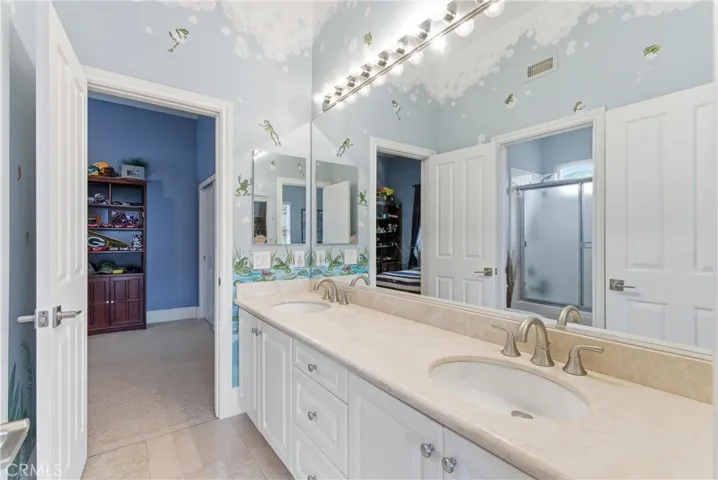 Secondary bathroom with dual vanities, spacious countertops, and functional access connecting the adjoining bedrooms