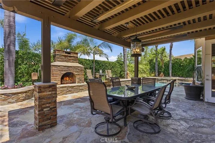 Covered outdoor entertaining area, a stone fireplace, and multiple seating spaces