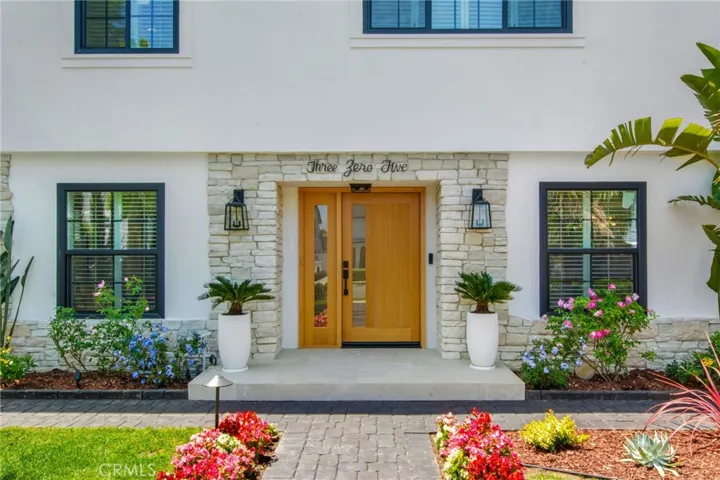 Custom fluted white oak entry door framed in stone | 305 Robinhood Ln., Eastside Costa Mesa 92627