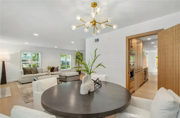 Dining area flowing seamlessly into the chef's kitchen | 305 Robinhood Ln., Eastside Costa Mesa 92627