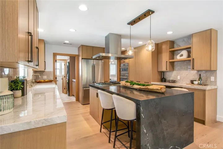 Black Diamond quartzite waterfall island with counter seating | 305 Robinhood Ln., Eastside Costa Mesa 92627