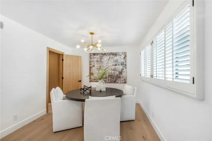 Dining area with statement chandelier off the chef's kitchen | 305 Robinhood Ln., Eastside Costa Mesa 92627