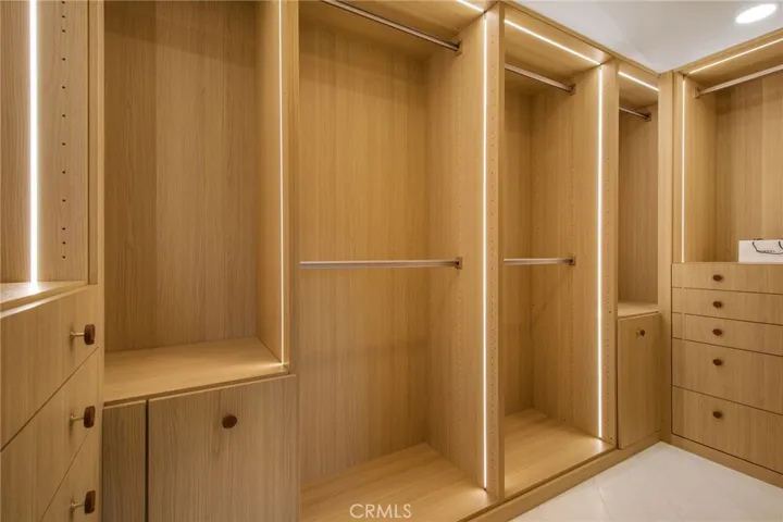 Built-out walk-in dressing room in white oak millwork with integrated LED lighting | 305 Robinhood Ln., Eastside Costa Mesa 92627