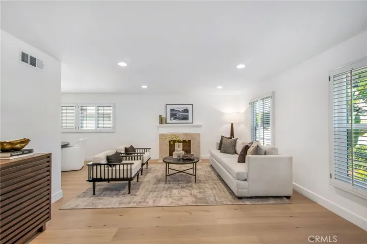 Light-filled formal living room with designer lighting and plantation shutters | 305 Robinhood Ln., Eastside Costa Mesa 92627