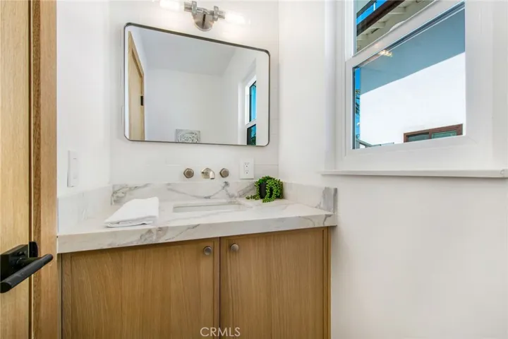 Downstairs designer powder bath finished in Calacatta Dolomiti | 305 Robinhood Ln., Eastside Costa Mesa 92627