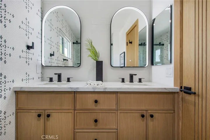 Designer hall bath with Calacatta Dolomiti vanity and arched lit mirrors | 305 Robinhood Ln., Eastside Costa Mesa 92627