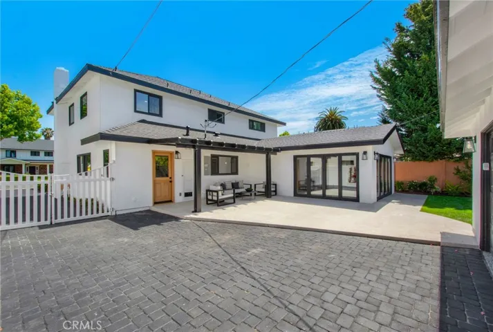 Private rear yard with premium stone hardscape and detached structure beyond | 305 Robinhood Ln., Eastside Costa Mesa 92627