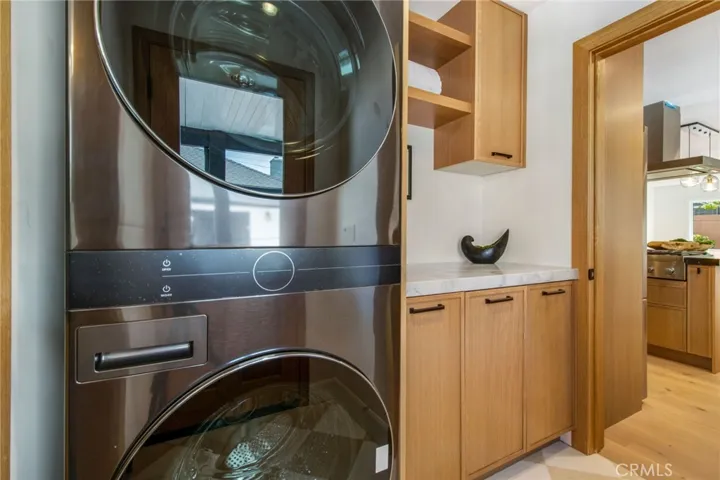 Laundry room with new washer, gas dryer, and white oak cabinetry | 305 Robinhood Ln., Eastside Costa Mesa 92627