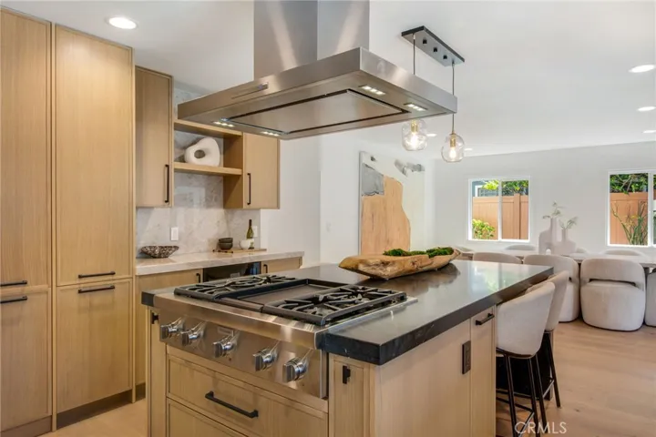 Black Diamond quartzite island with professional gas range and stainless island hood | 305 Robinhood Ln., Eastside Costa Mesa 92627
