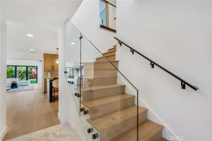 New white oak and glass staircase rises to the second level | 305 Robinhood Ln., Eastside Costa Mesa 92627