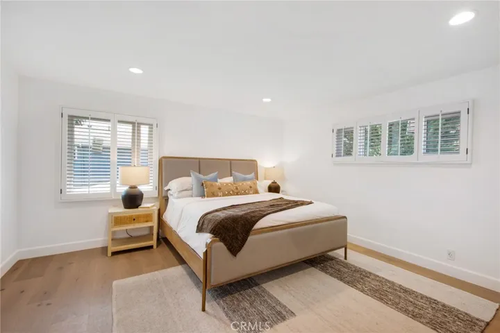 Primary bedroom suite with European white oak floors and plantation shutters | 305 Robinhood Ln., Eastside Costa Mesa 92627
