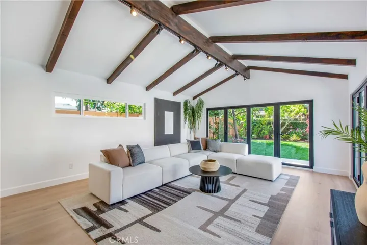 Great room with restored exposed timber beams and vaulted ceilings looking out toward the backyard| 305 Robinhood Ln., Eastside Costa Mesa 92627