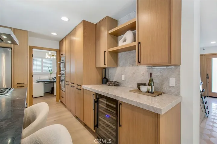 Integrated wine refrigerator and bar area within the chef's kitchen | 305 Robinhood Ln., Eastside Costa Mesa 92627