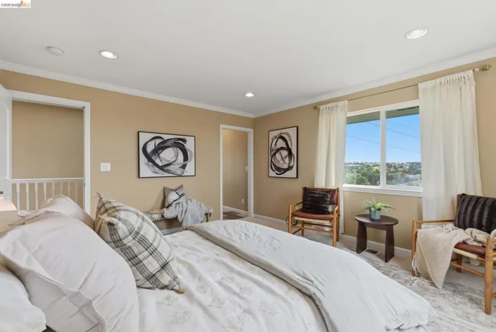 Bedroom featuring recessed ceiling lighting, crown molding, and a large window