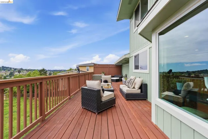 Spacious outdoor deck featuring rich wood-finish flooring and a matching wooden railing