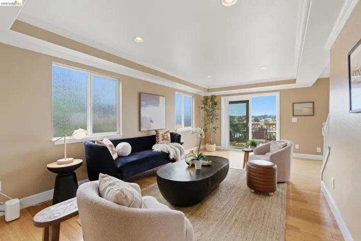 Living area featuring wood-finish flooring, recessed lighting, crown molding, and neutral wall tones