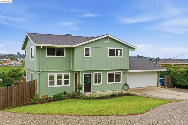 Two-story residence with light green siding and white trim