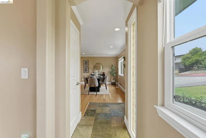 Entryway featuring slate tile flooring, archway detailing, and a clear interior door